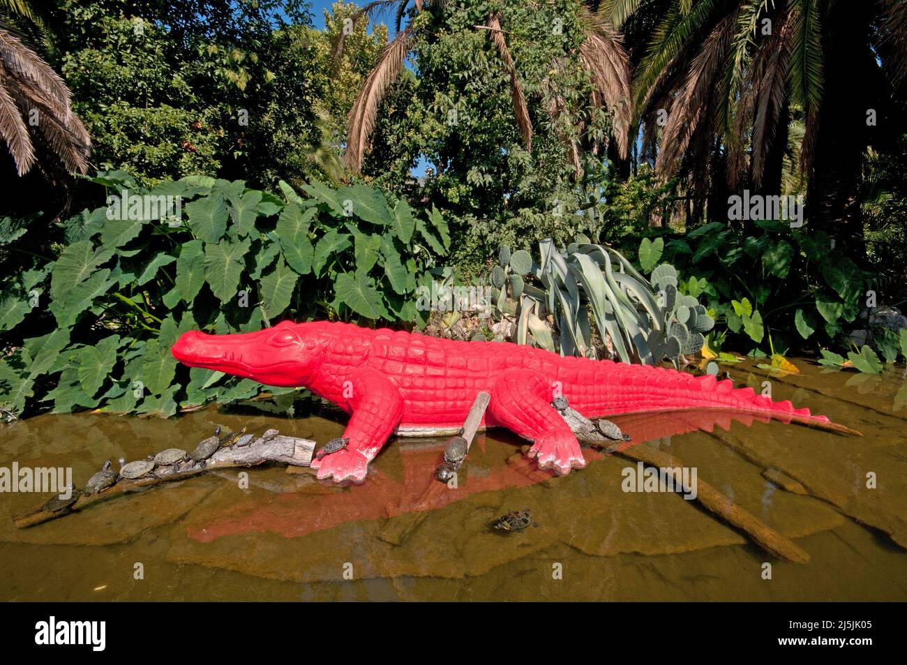 Scultura rossa di coccodrillo e gruppo di tartarughe rosse (chrysemys scripta), Bioparco, Roma, Italia Foto Stock