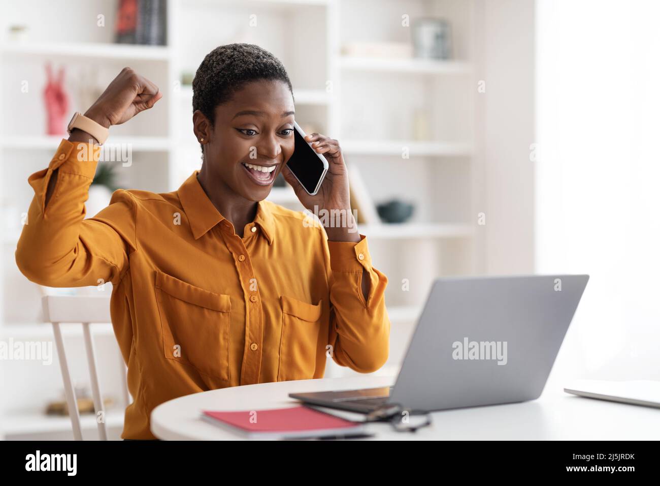 Imprenditore emotivo femminile che lavora online, parlando sul telefono cellulare Foto Stock