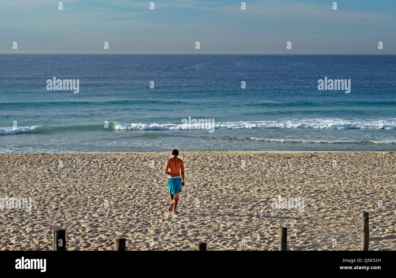 Giovane che cammina sulla spiaggia barra da Tijuca Foto Stock