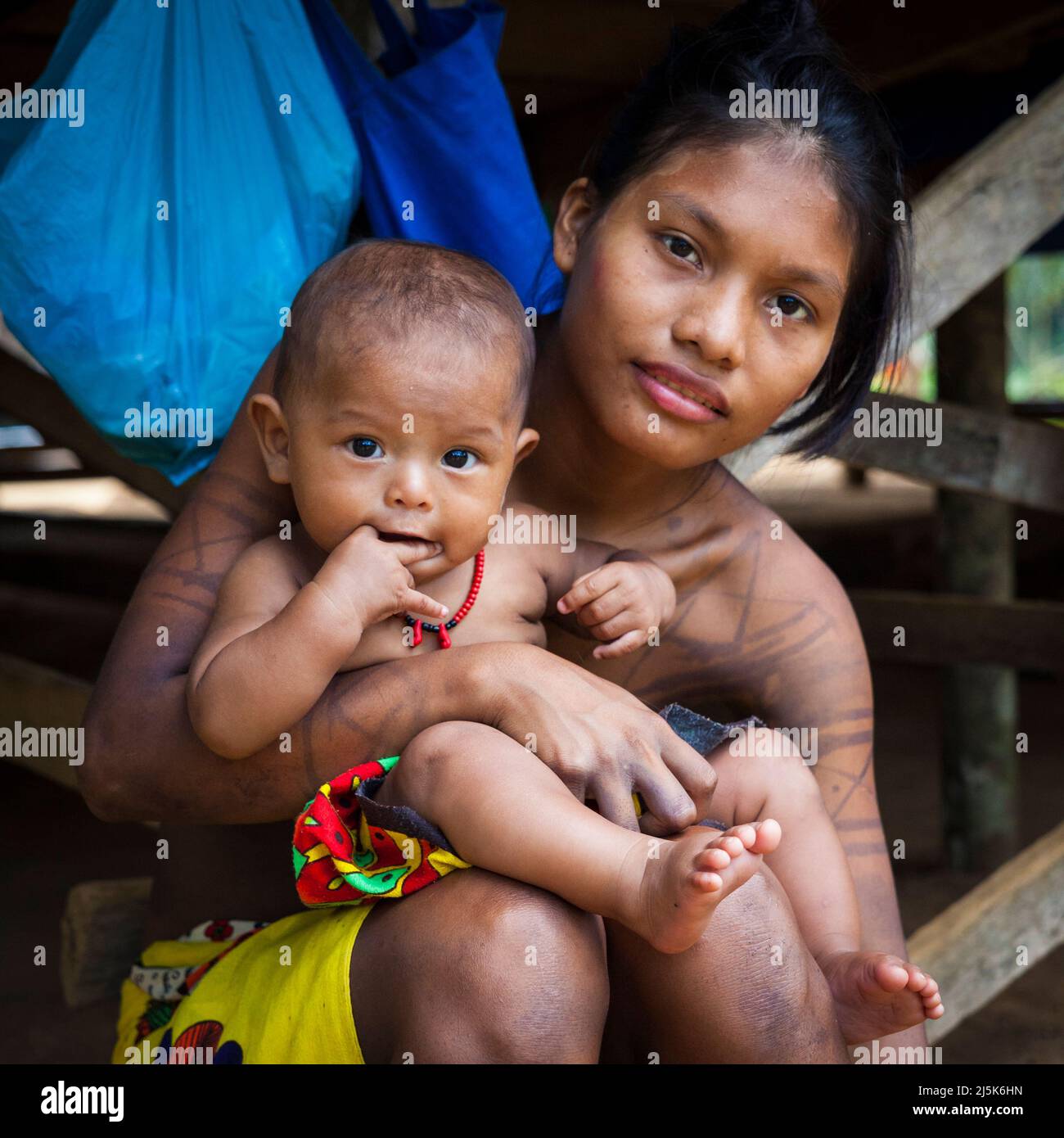 Donna indiana di Embera con bambino nel villaggio di Embera Puru accanto a Rio Pequeni, al confine tra le province di Panama e Colon, Repubblica di Panama. Foto Stock