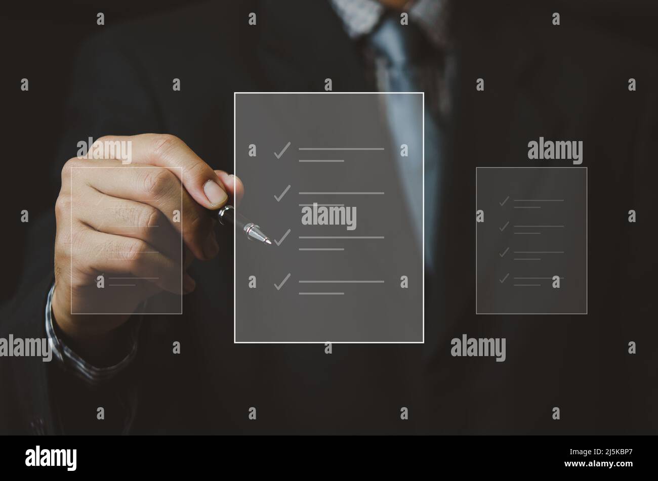 uomo d'affari che tiene la penna per controllare i documenti digitali di affari sullo schermo virtuale. Foto Stock