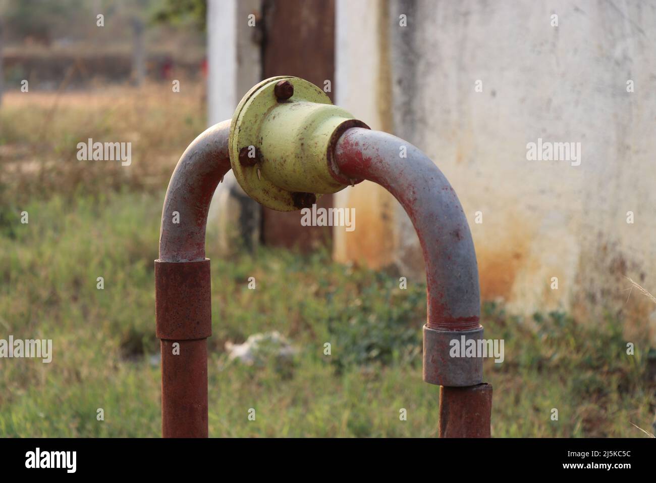 Vecchio motore borewell e sistema di pompaggio con tubazioni zincate per l'uscita dell'acqua con valvola di non ritorno progettata per l'irrigazione Foto Stock