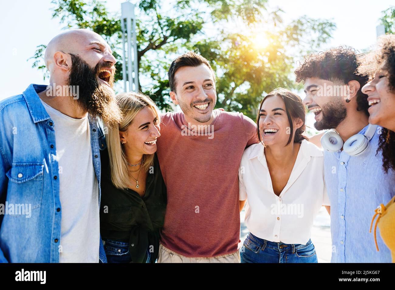 Gruppo di giovani amici sorridenti che si divertono insieme all'aperto Foto Stock