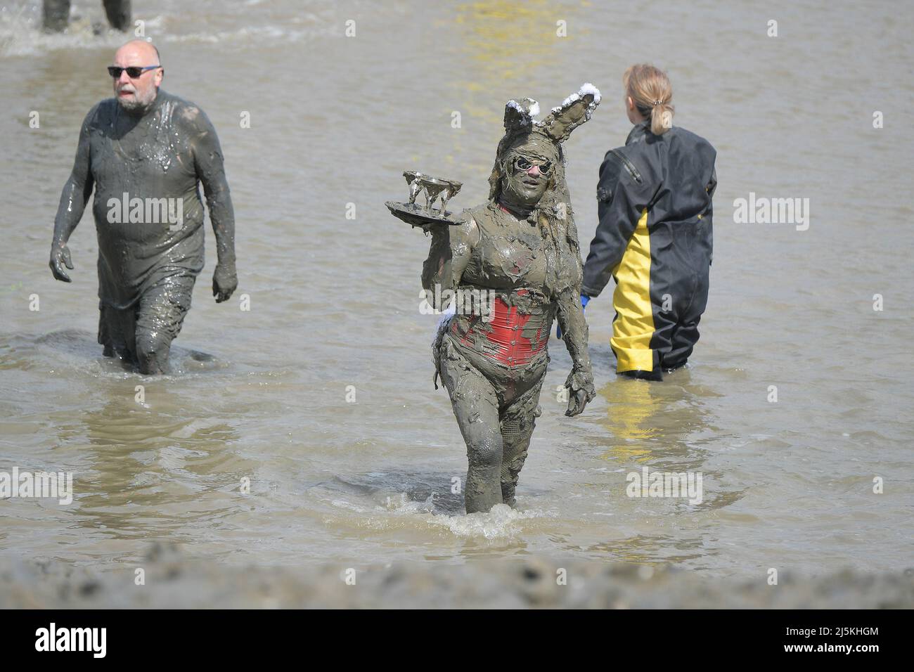 Maldon Essex Regno Unito. 24th Apr 2022. La gara di Maldon Mud torna a Promenade Park nella città dell'Essex dopo un'assenza di due anni dovuta a Covid-19. La gara si svolge su un percorso di 450 metri attraverso il fiume Blackmore e può avvenire solo con bassa marea. Questo evento è nato nel 1973, quando un uomo locale è stato sfidato a indossare un tuxedo per servire un pasto sulla riva del fiume. In seguito, la gente del posto ha dovuto bere una pinta da un barile di birra in attesa prima di tornare a correre. Credit: MARTIN DALTON/Alamy Live News Foto Stock