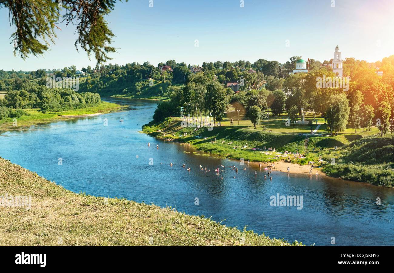 Rzhev, Russia, giugno 2021. Paesaggio urbano estivo con vista sul fiume Volga e gente sulla riva. Le persone nuotano e si prendere il sole. Foto Stock