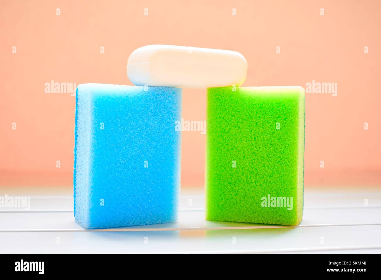 Due spugne colorate e sapone bianco per la pulizia Foto Stock
