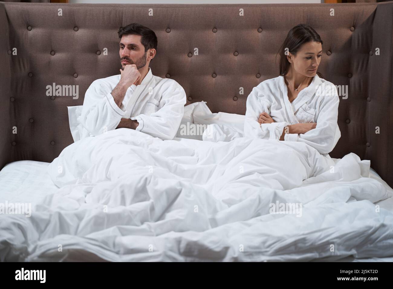 Moglie risentita a letto allontanandosi dal marito Foto Stock