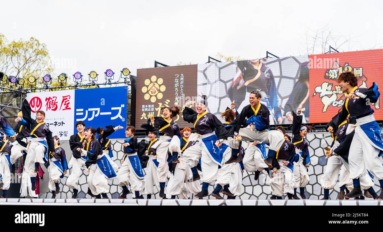 Squadra giapponese di ballerini Yosakoi che ballano in toniche yukata e tengono naruko, clappers, sul palco all'aperto al festival Kyusyu Gassai di Kumamoto. Foto Stock