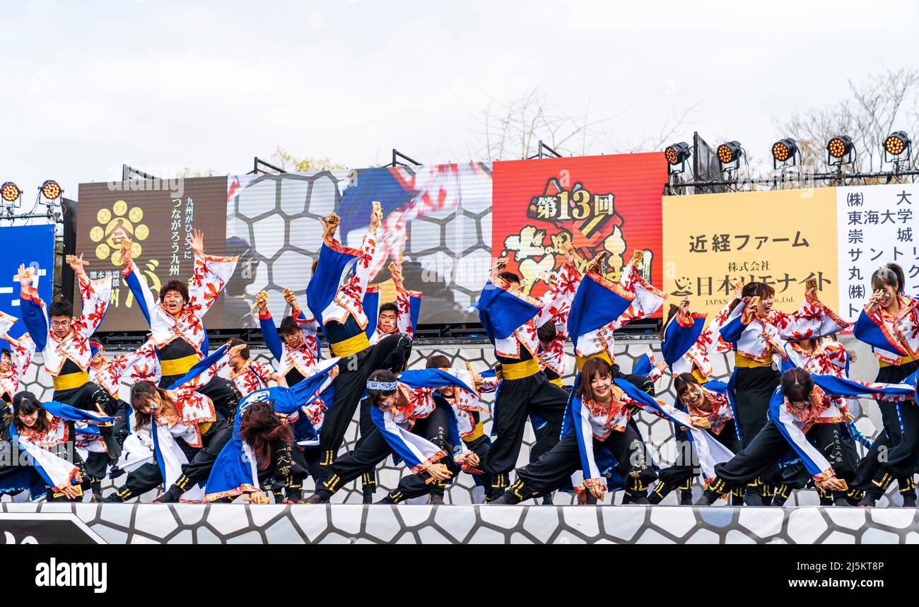 Squadra giapponese di ballerini Yosakoi che ballano in toniche yukata e tengono naruko, clappers, sul palco all'aperto al festival Kyusyu Gassai di Kumamoto. Foto Stock