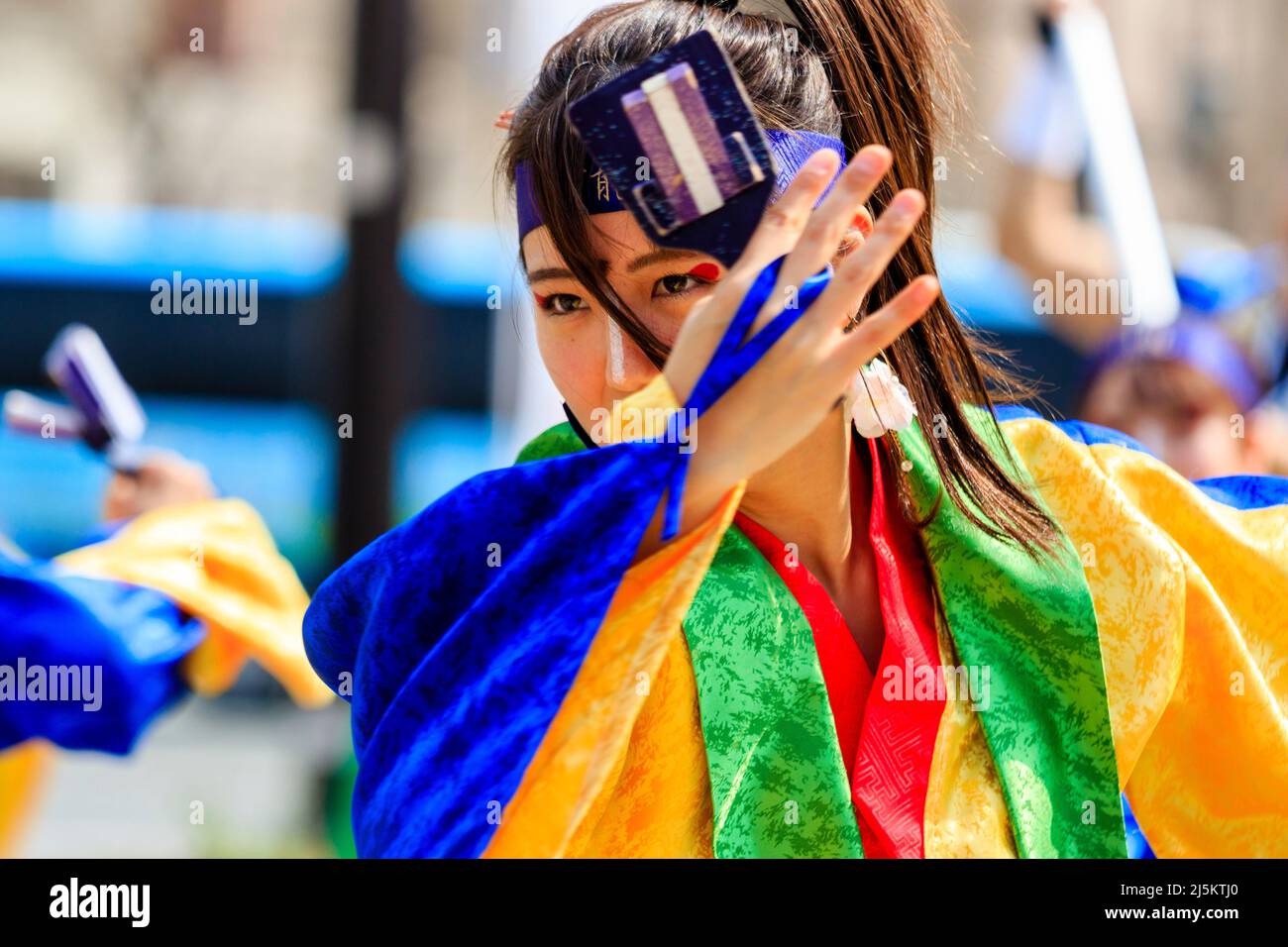 Primo piano degli occhi di una giovane ballerina giapponese Yosakoi con la mano che tiene il naruko, clapper di legno, alla festa di Kyusyu Gassai a Kumamoto. Foto Stock