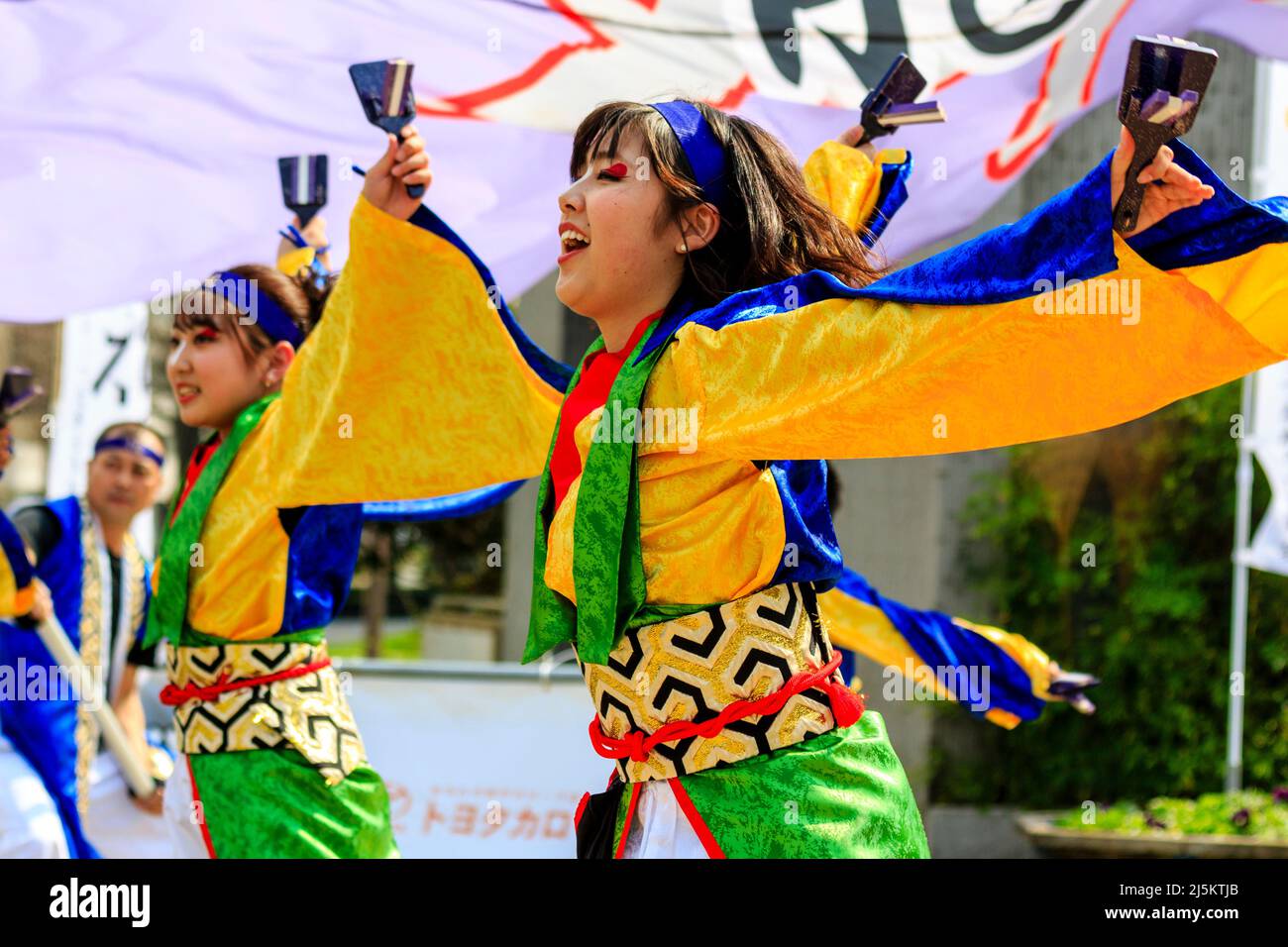 Due giovani giapponesi ballerine Yosakoi in tonica yukata e con naruko, clappers, all'aperto durante la primavera del festival Kyusyu Gassai a Kumamoto. Foto Stock