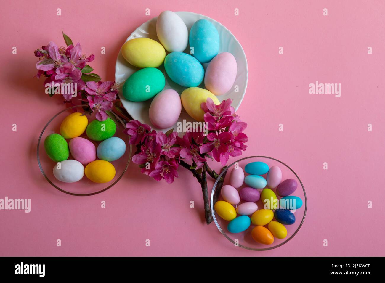 Buona Pasqua! Carta di Pasqua con un'immagine di uova colorate con uova colorate di gallina, piccione e quaglia decorate con fiori su sfondo rosa Foto Stock