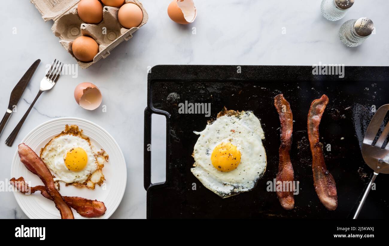 La colazione comprende uova e pancetta. Foto Stock