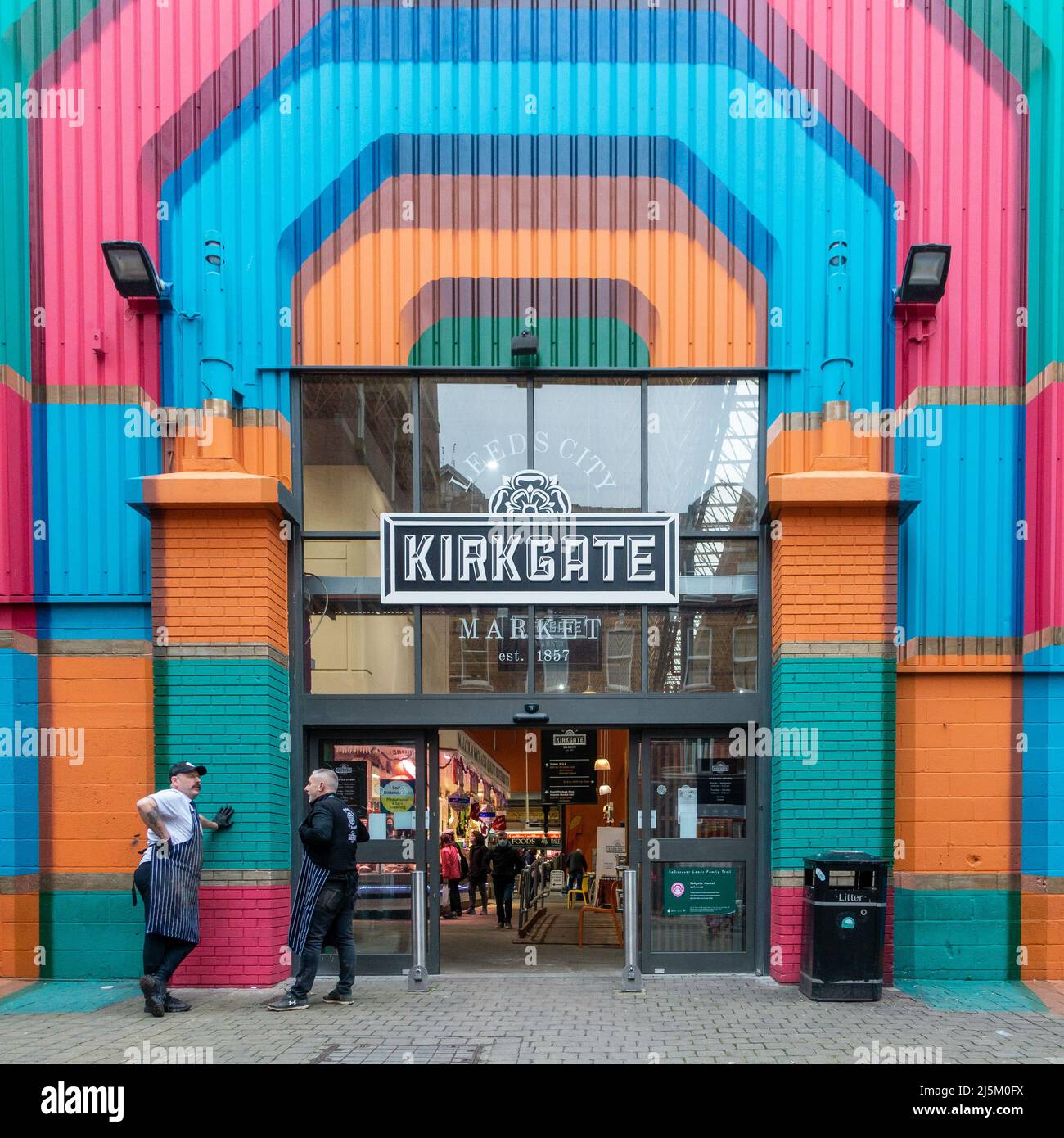 Leeds Kirkgate mercato colorato ingresso laterale con due commercianti di mercato che hanno una pausa e una chiacchierata fuori, Leeds centro città, West Yorkshire, Inghilterra Regno Unito Foto Stock
