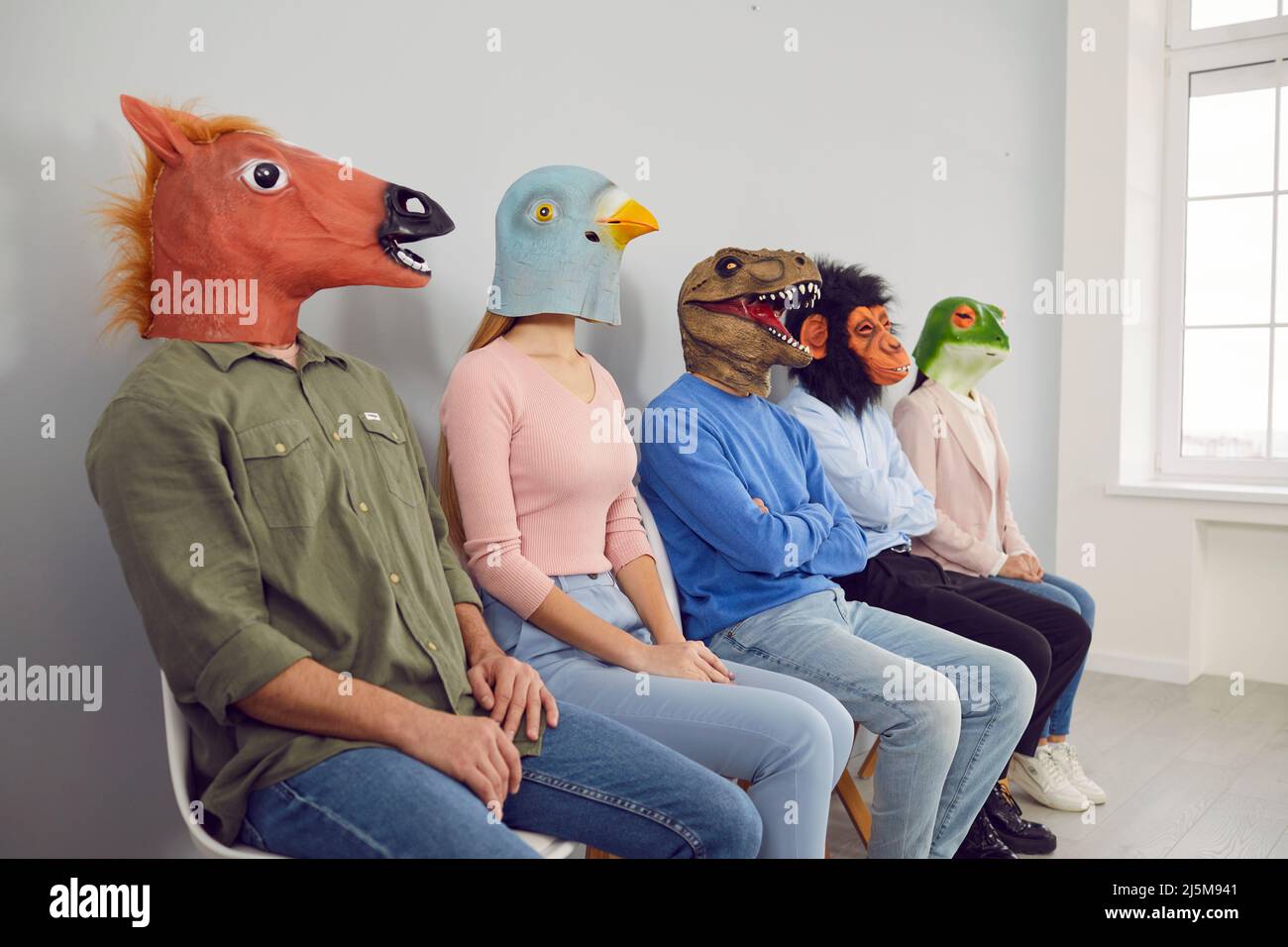 Persone diverse in maschere animali in linea in ufficio Foto Stock