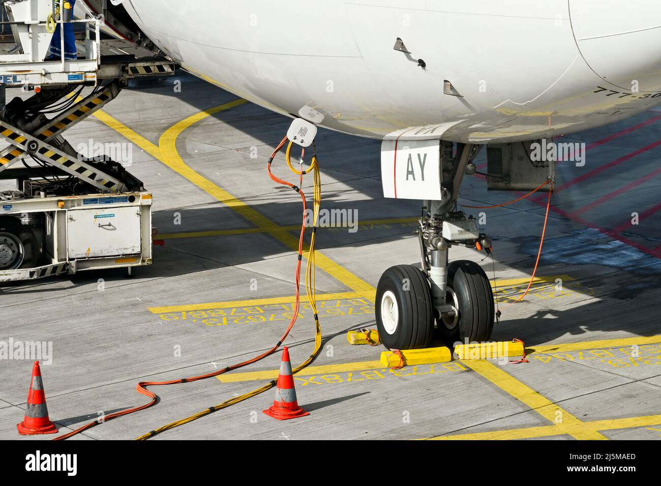 Francoforte, Germania - Aprile 2022: Cavi di alimentazione collegati a un jet Boeing 777. I cavi forniscono energia elettrica all'aeromobile a terra Foto Stock