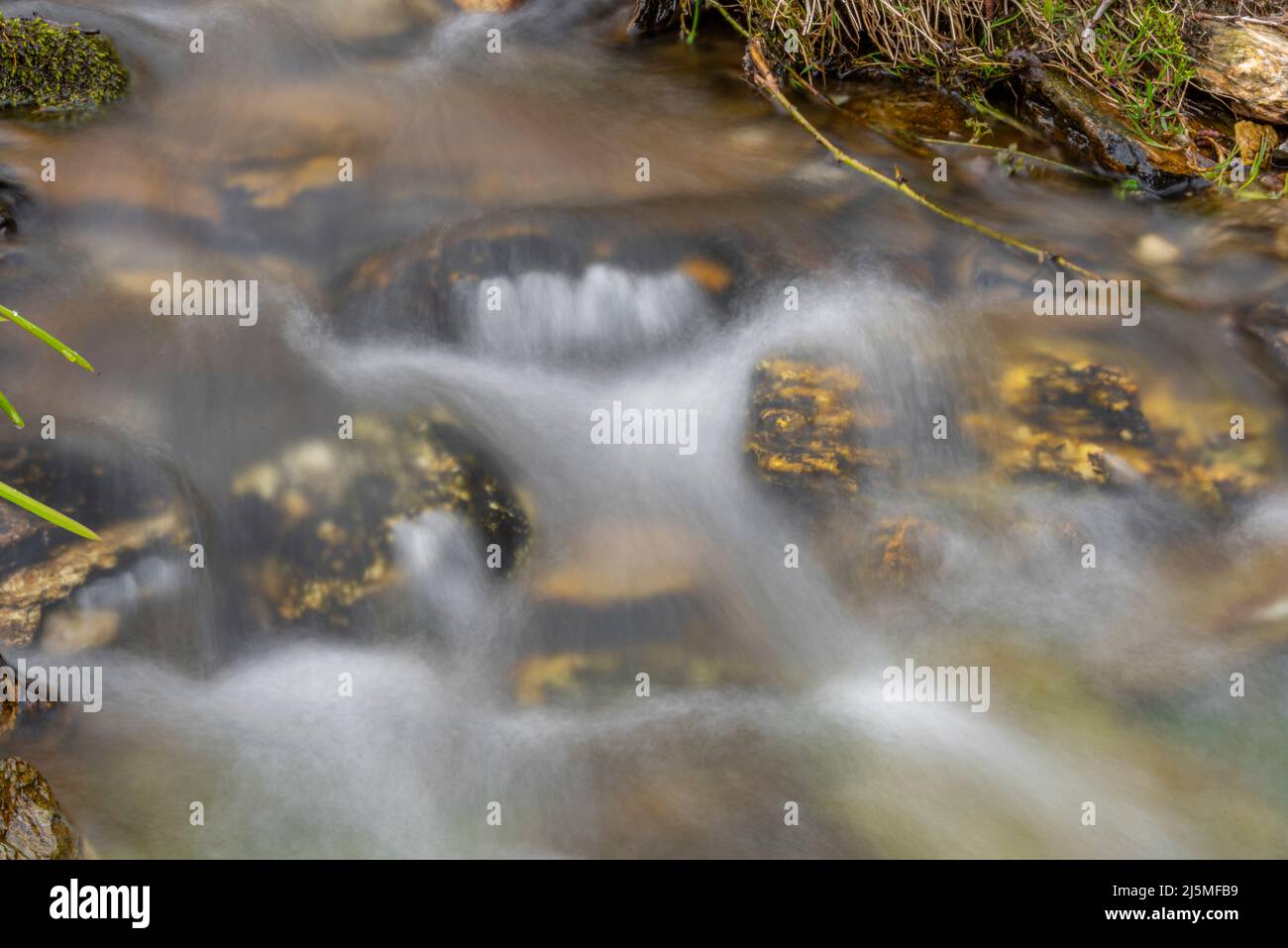 Acqua fresca di colore pulita in montagna ruscello con belle pietre di colore Foto Stock