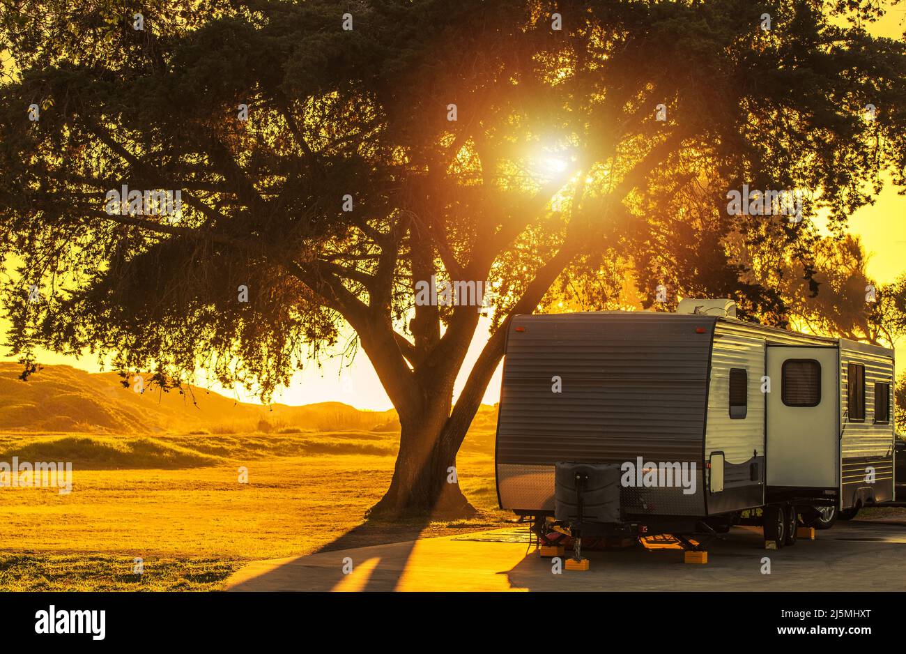 Scenic California Coastal RV Recreational Vehicles Park Travel Trailer Camping durante il tramonto. Tema RVing. Foto Stock