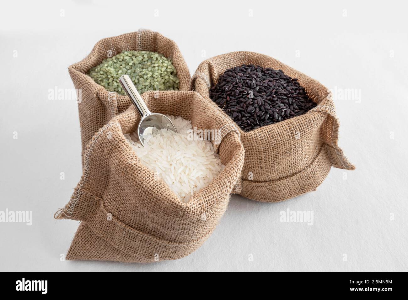 Tre varietà di riso, verde, bianco e nero, in sacchi di hessian Foto Stock