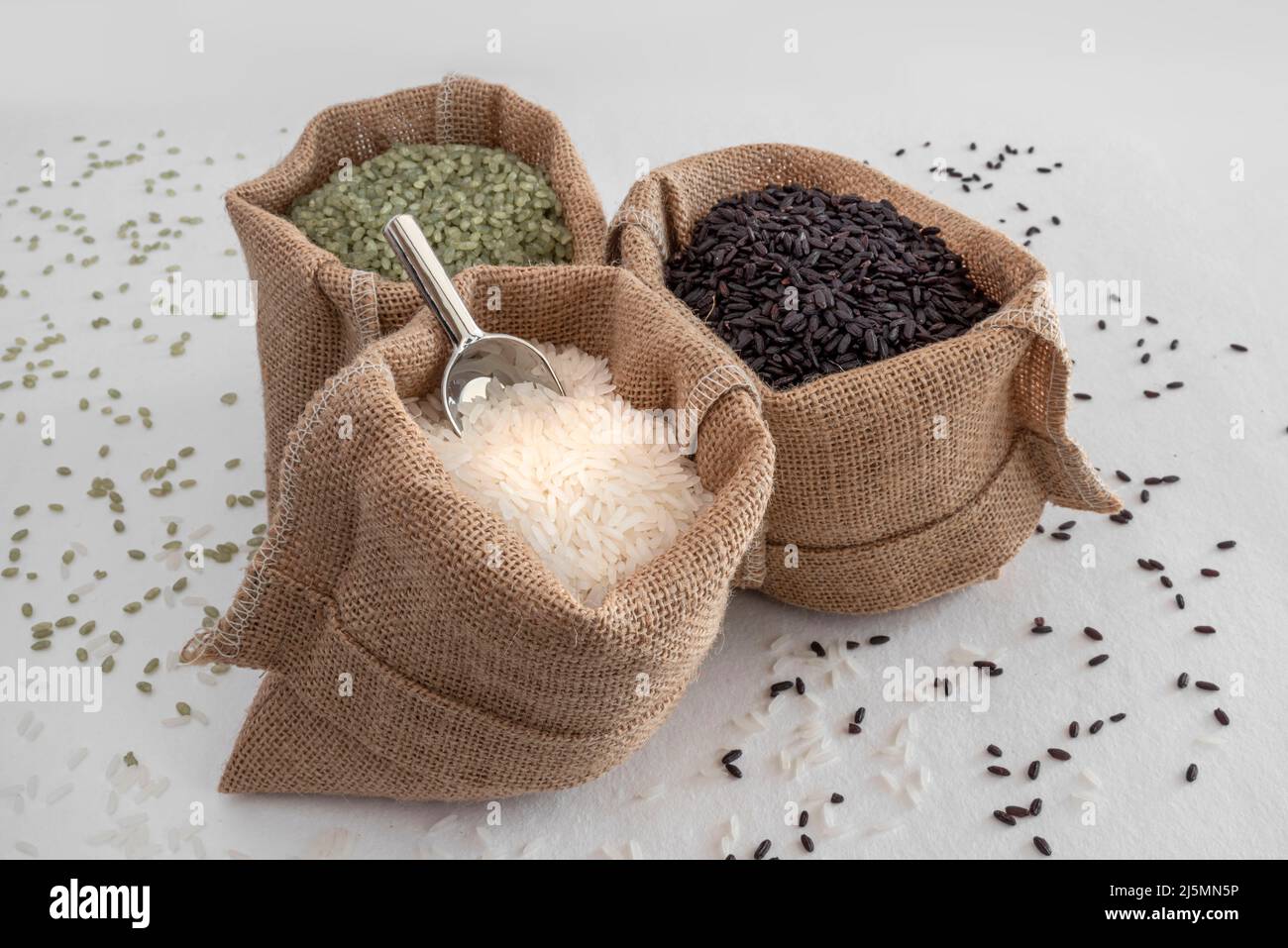 Tre varietà di riso, verde, bianco e nero, in sacchi di hessian Foto Stock