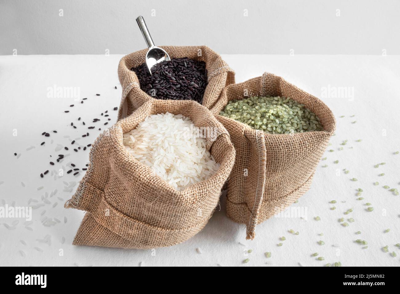 Tre varietà di riso, verde, bianco e nero, in sacchi di hessian Foto Stock