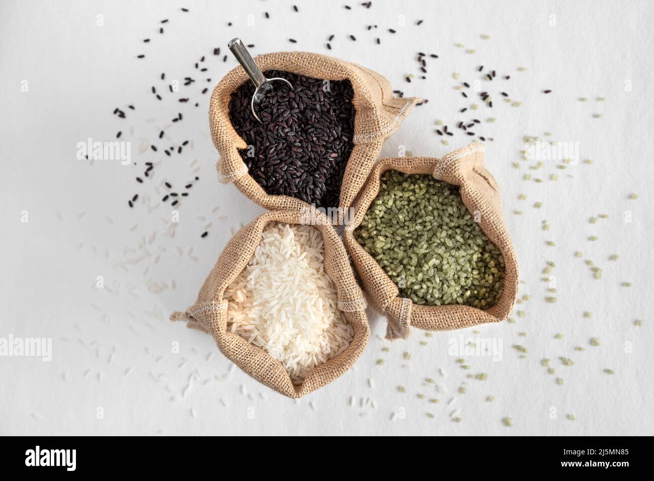 Tre varietà di riso, verde, bianco e nero, in sacchi di hessian Foto Stock
