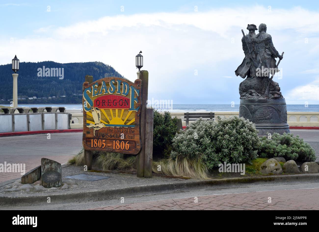 Un cartello sul lungomare per la cittadina turistica costiera di Seaside, Oregon, USA con una statua degli esploratori Lewis e Clark sulla destra. Foto Stock