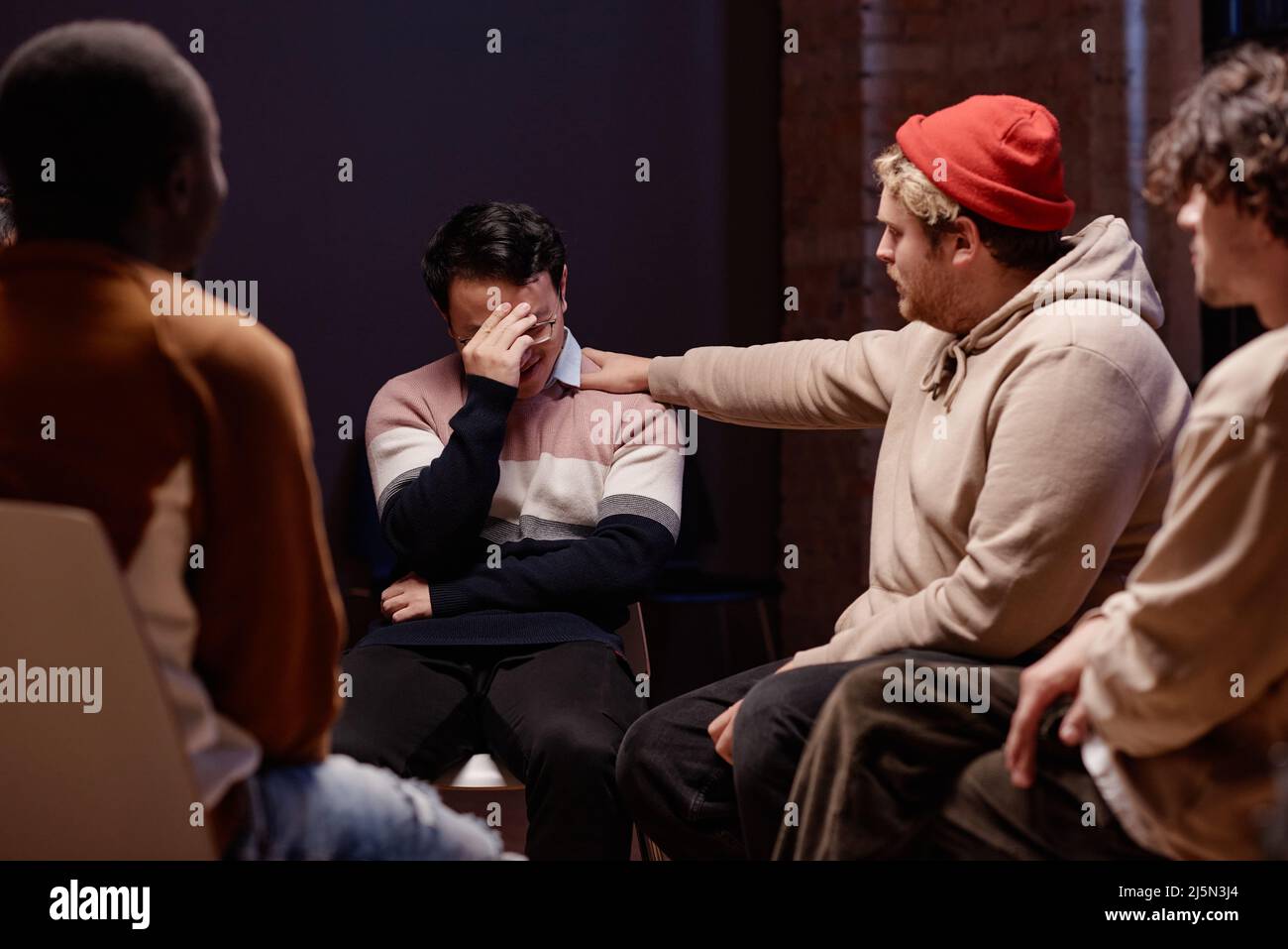 Gruppo di giovani uomini che hanno una sessione di psicoterapia ottenere aiuto condividere pensieri e sostenersi a vicenda Foto Stock