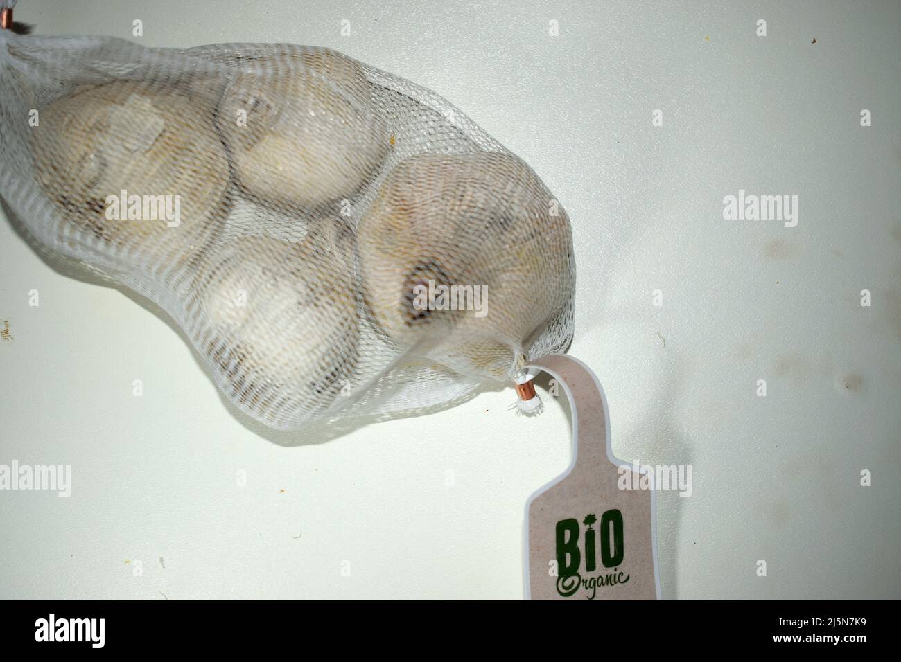 Rete di frutta all'aglio biologico con un'etichetta indicante il prodotto biologico sulla tabella Foto Stock
