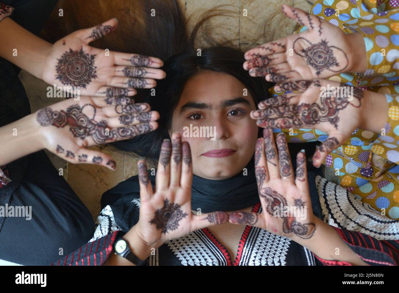 Lahore, Pakistan. 24th Apr 2022. Le ragazze pakistane hanno decorazioni  all'henné applicate sulle loro mani a casa loro per il prossimo festival  musulmano di Eid al-Fitr a Lahore. I musulmani di tutto