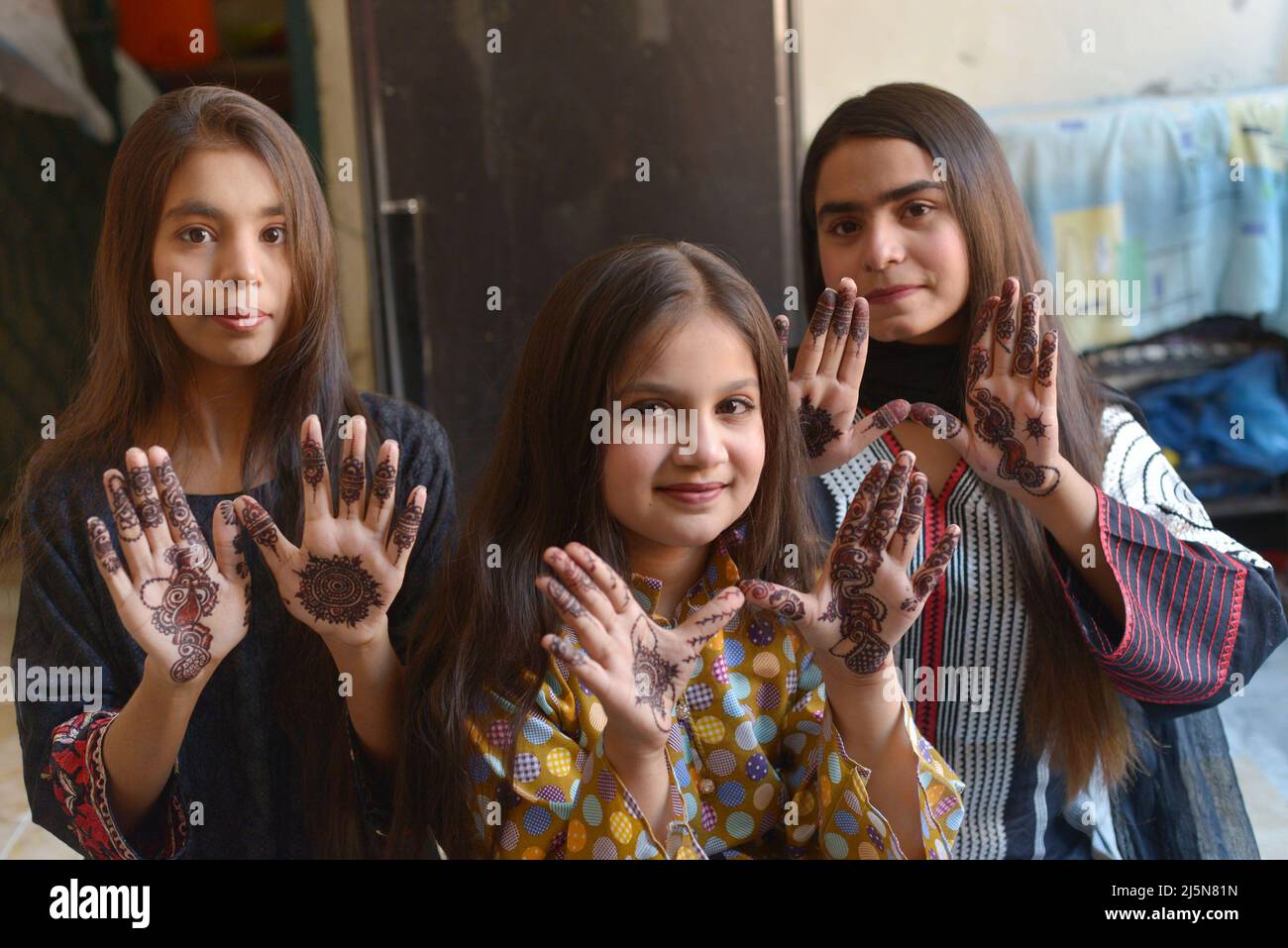 Lahore, Punjab, Pakistan. 24th Apr 2022. Le ragazze pakistane hanno  decorazioni all'henné applicate sulle loro mani a casa loro per il prossimo  festival musulmano di Eid al-Fitr a Lahore. I musulmani di