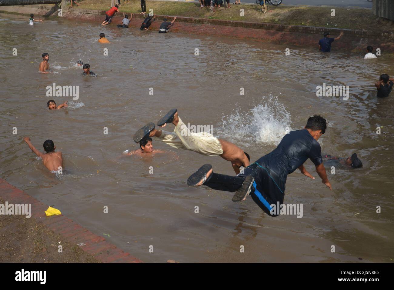 Lahore, Punjab, Pakistan. 24th Apr 2022. Il giovane pakistano si gode il bagno in acqua di canale per battere il calore e ottenere un po 'di sollievo dal clima caldo a Ramazan-ul-Mubarak a Lahore. (Credit Image: © Rana Sajid Hussain/Pacific Press via ZUMA Press Wire) Foto Stock