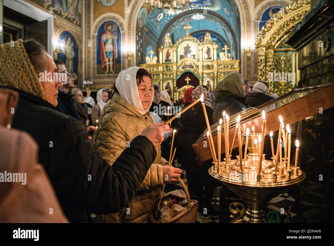 Le donne illuminano le candele come segno di luce e purezza all'interno della Cattedrale della Chiesa Ortodossa in Moldavia. La Pasqua a Chisinau è stata celebrata quest'anno sotto leggera tensione. Il conflitto armato nel territorio del paese confinante, l'Ucraina, ha modificato l'attuale panorama moldavo. Durante l'ultima settimana, gli allarmi sono stati riattivati a causa di presunte informazioni diffuse che potrebbero estendere la battaglia a questo paese. In questo scenario quest'anno migliaia di persone sono uscite a chiedere la pace. La Pasqua viene tradizionalmente celebrata ogni anno nel mese di aprile, l'ultima celebrazione è la Foto Stock