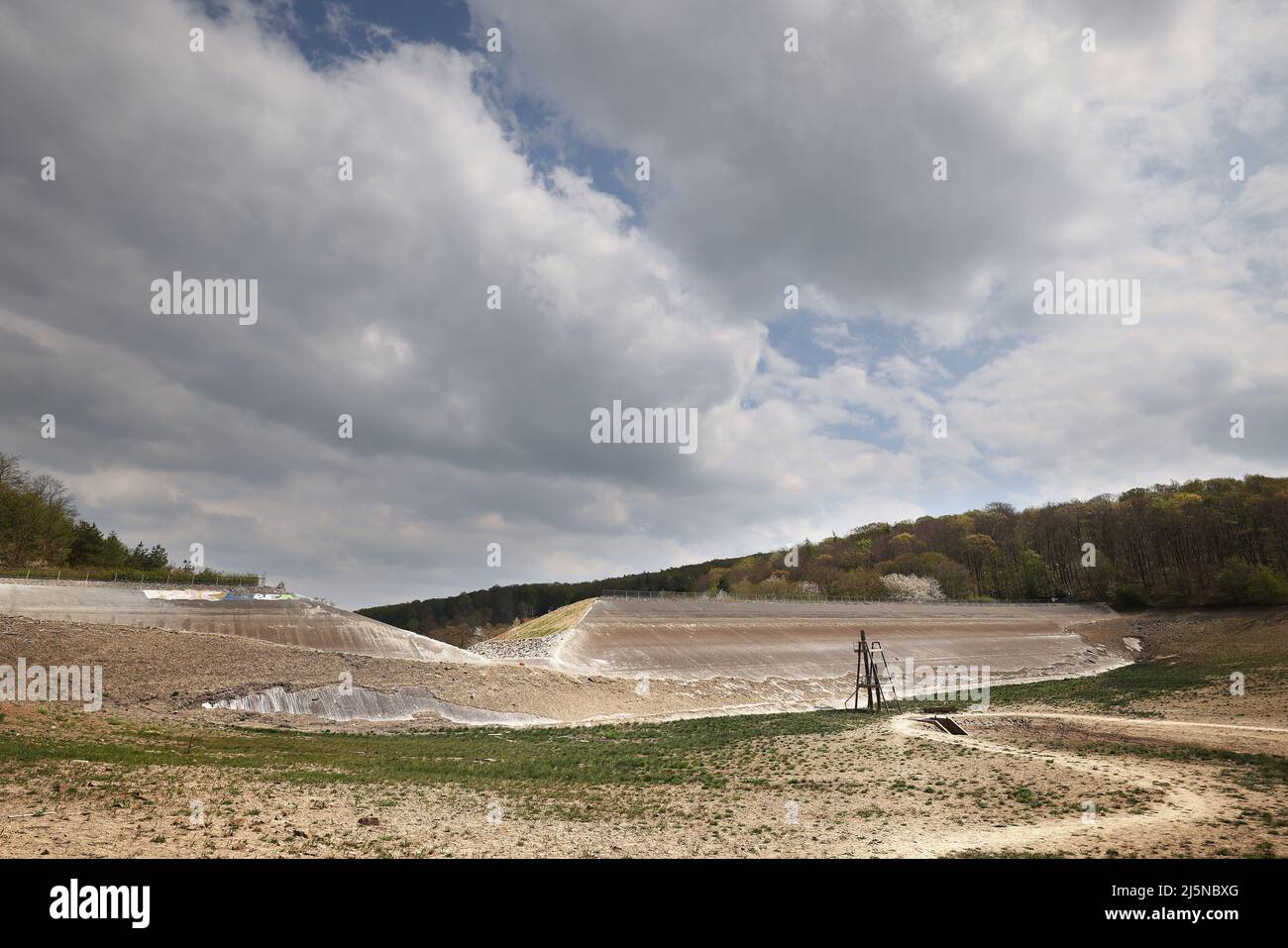 22 Aprile 2022, Renania Settentrionale-Vestfalia, Bad Münstereifel: Un notch può essere visto nella diga della diga di Steinbach. Dopo la minaccia di rottura della diga nell'alluvione del luglio 2021, è stato costruito un canale nella diga attraverso il quale l'acqua può defluire durante alti livelli di acqua. (A dpa: 'Dopo pericolo di scoppio diga: Canale di drenaggio per la diga di Steinbach quasi finito') Foto: Oliver Berg/dpa Foto Stock