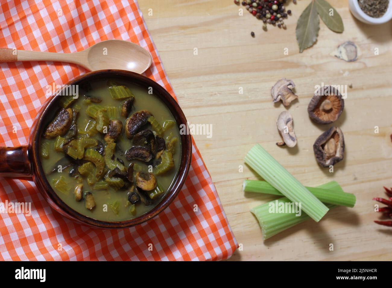 Sostanziosa zuppa di funghi e sedano con brodo vegetale piccante in cucina rustica Foto Stock