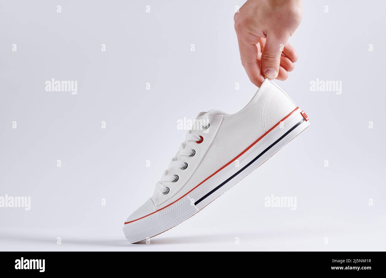 Sneaker casual su sfondo bianco, minimalismo creativo Foto Stock