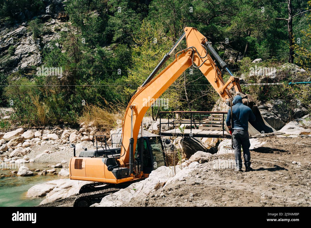 Escavatore dragline per macchinari pesanti scavando terreno nel canyon di montagna. Degger che lavora su una miniera d'oro in montagna. Attrezzatura mineraria Foto Stock