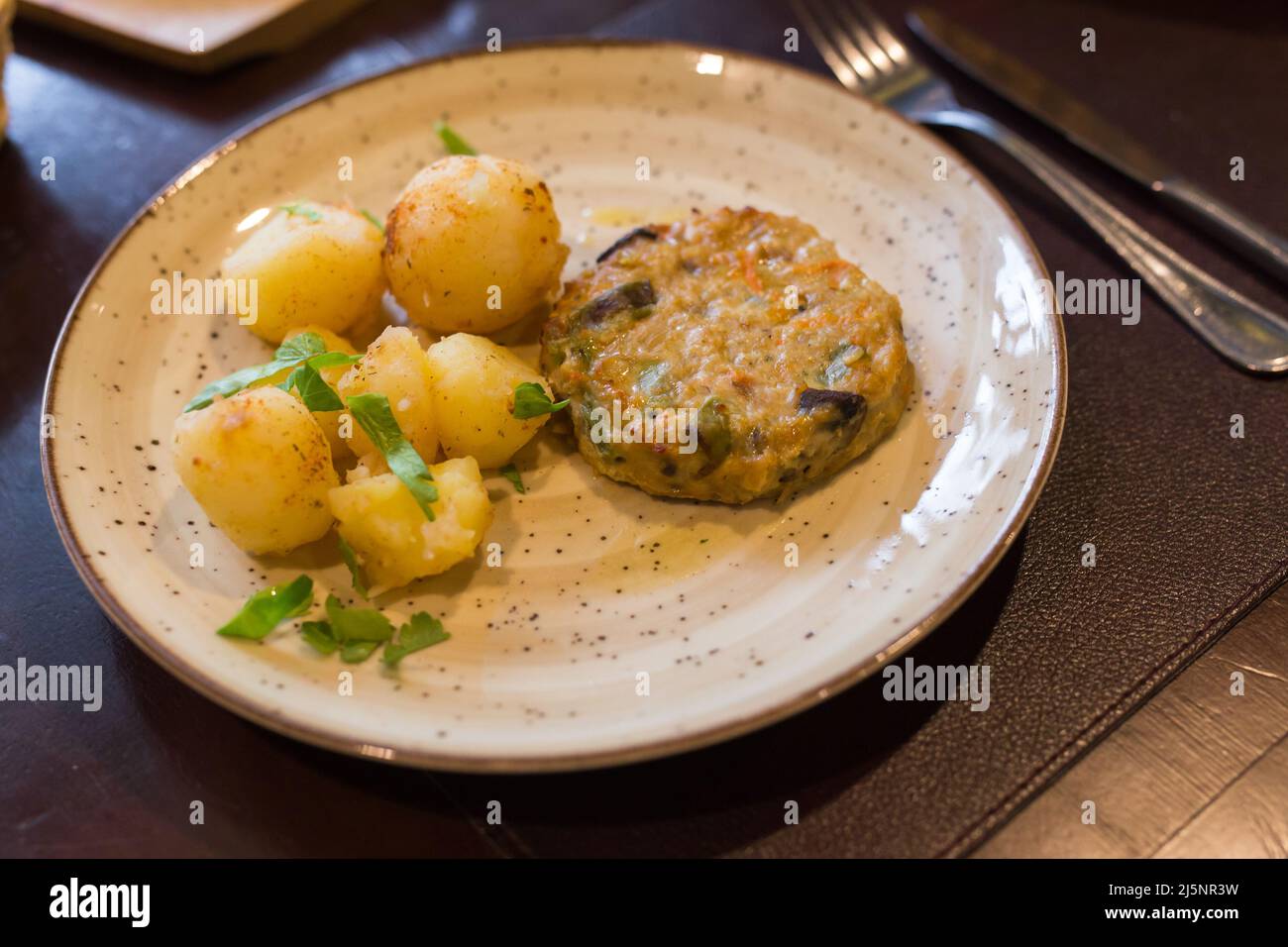 hamburger di pollo con patate bollite sul piatto Foto Stock