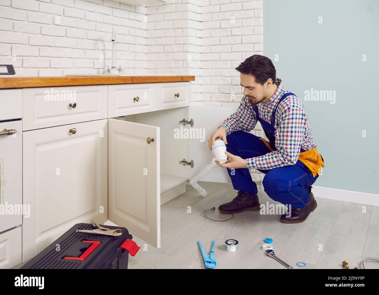 Maschio idraulico riparazione sistema di acqua in casa del cliente Foto Stock
