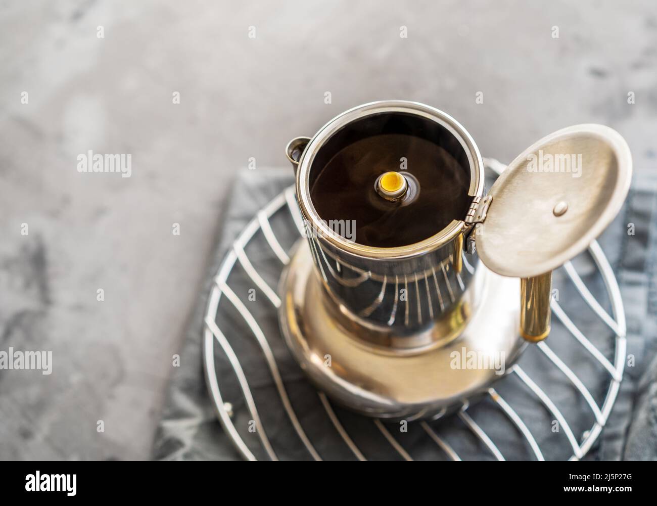 Caffè appena fatto in una caffettiera su sfondo grigio Foto Stock