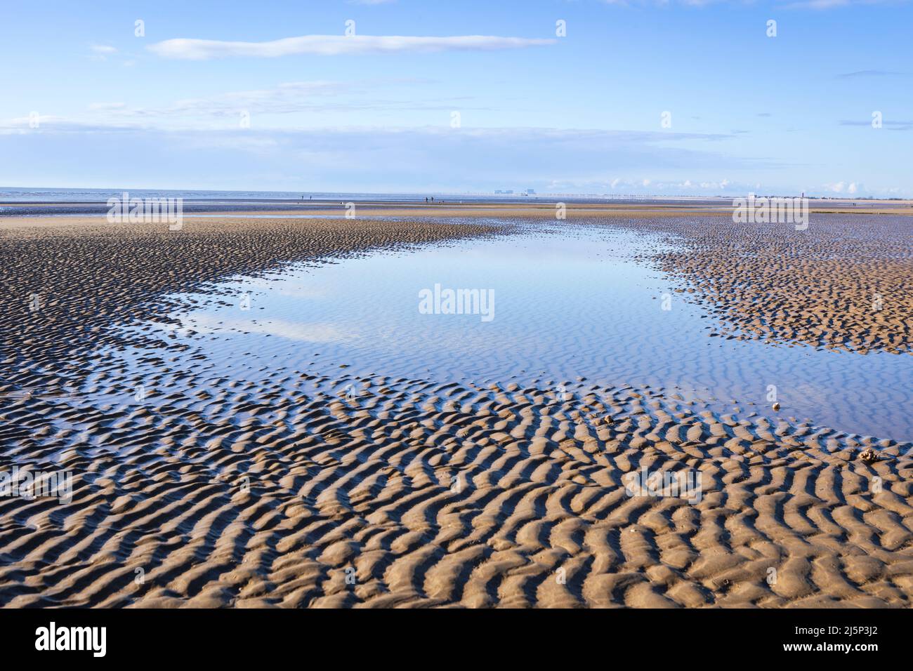 Bassa marea condizioni calme e una soleggiata mattinata di aprile a Dymchurch spiaggia sulla costa del Kent sud-est Inghilterra Regno Unito Foto Stock