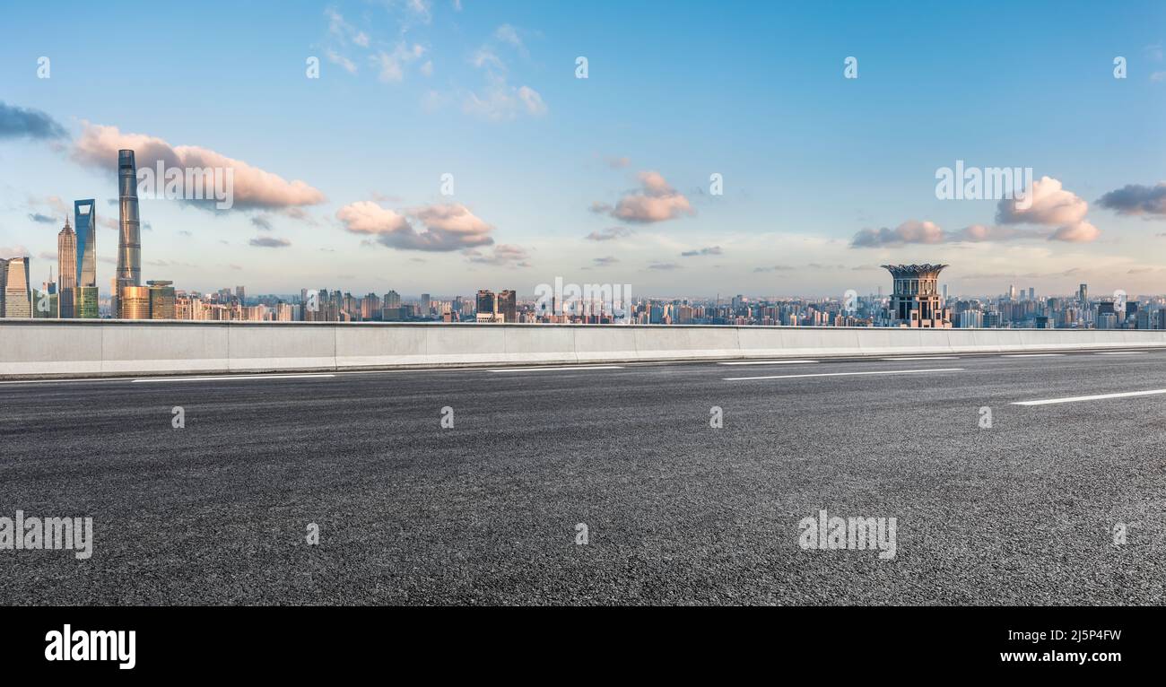 Asfalto autostrada e skyline della città con edifici moderni a Shanghai al tramonto, Cina. Foto Stock