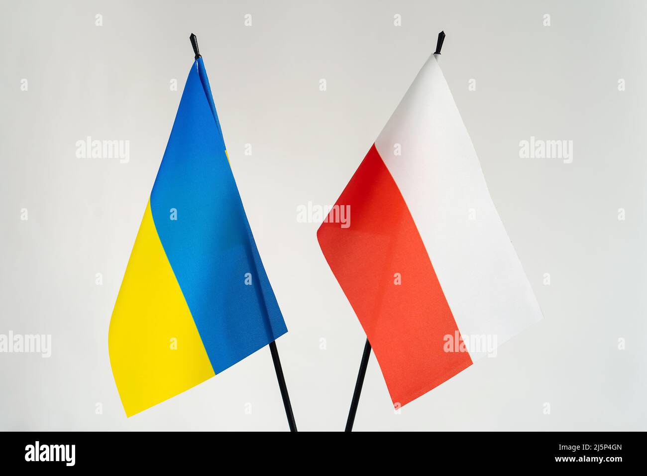 Bandiere di Stato di Ucraina e Polonia su sfondo bianco. Cooperazione e aiuto nel concetto di conflitto di guerra Foto Stock