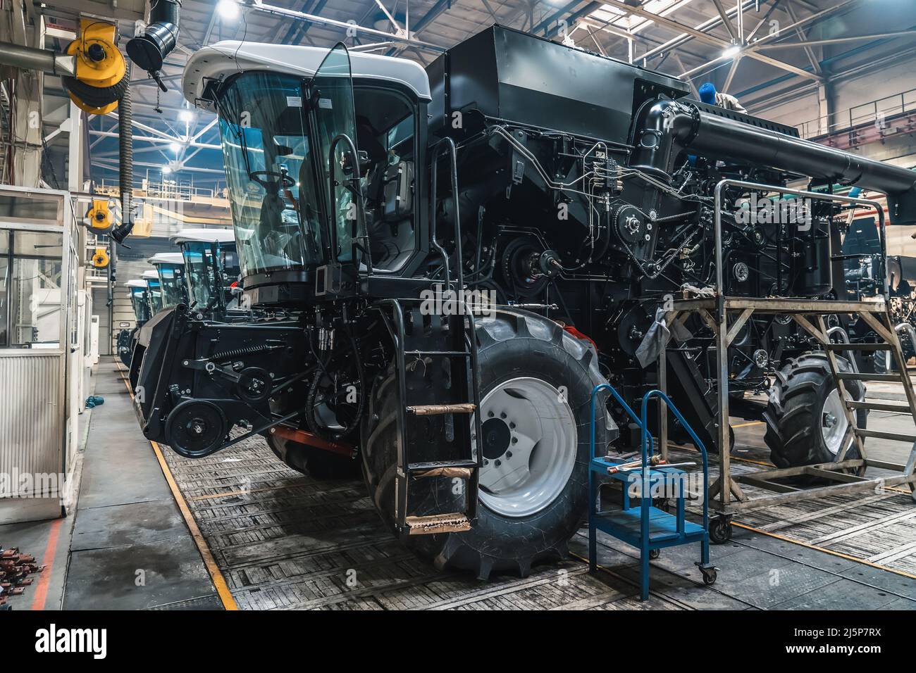 Processo di assemblaggio della mietitrebbia per veicoli agricoli in officina industriale. Foto Stock