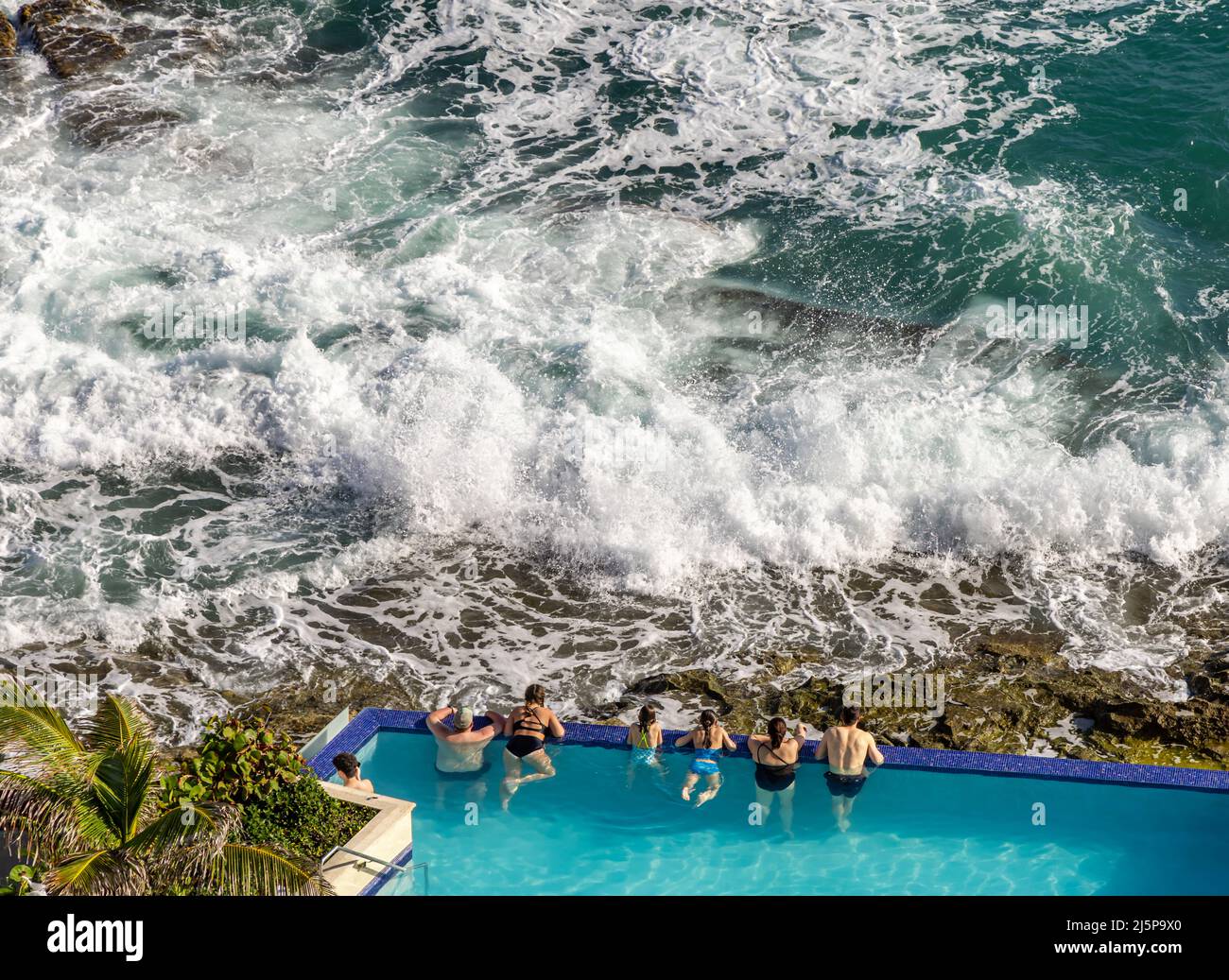 Persone in una piscina a sfioro guardando l'oceano al Condado Vanderbilt Hotel a San Juan Foto Stock