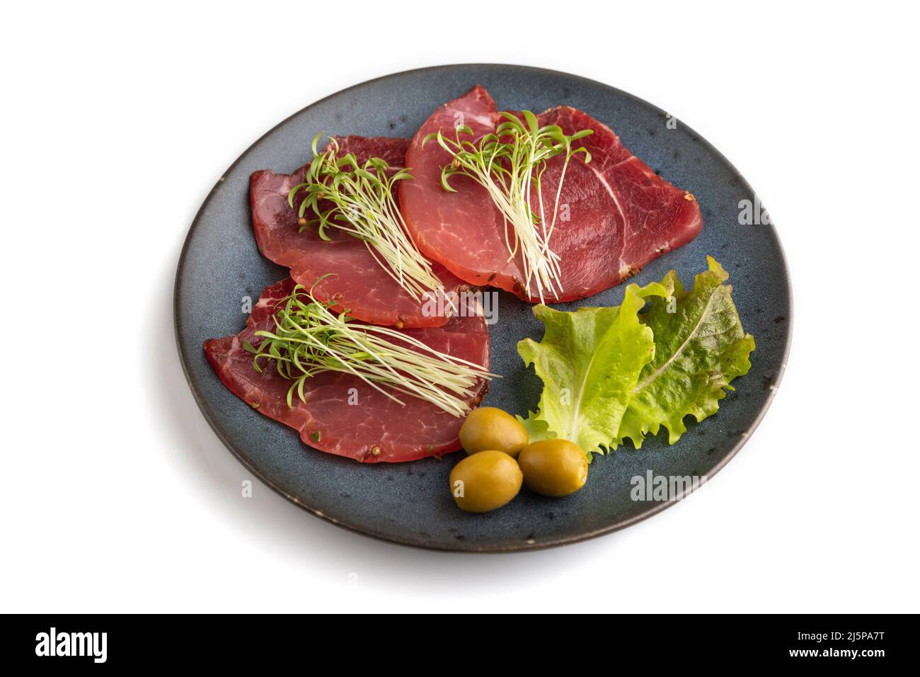 Fette di carne affumicata salata con coriandolo microfreen isolato su sfondo bianco. Vista laterale, primo piano. Foto Stock