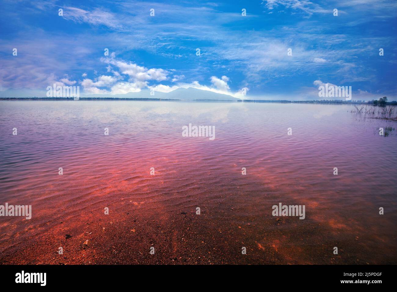 Foto di paesaggio grandangolare di lago tranquillo con acqua limpida sotto la nuvola e cielo blu. Foto Stock