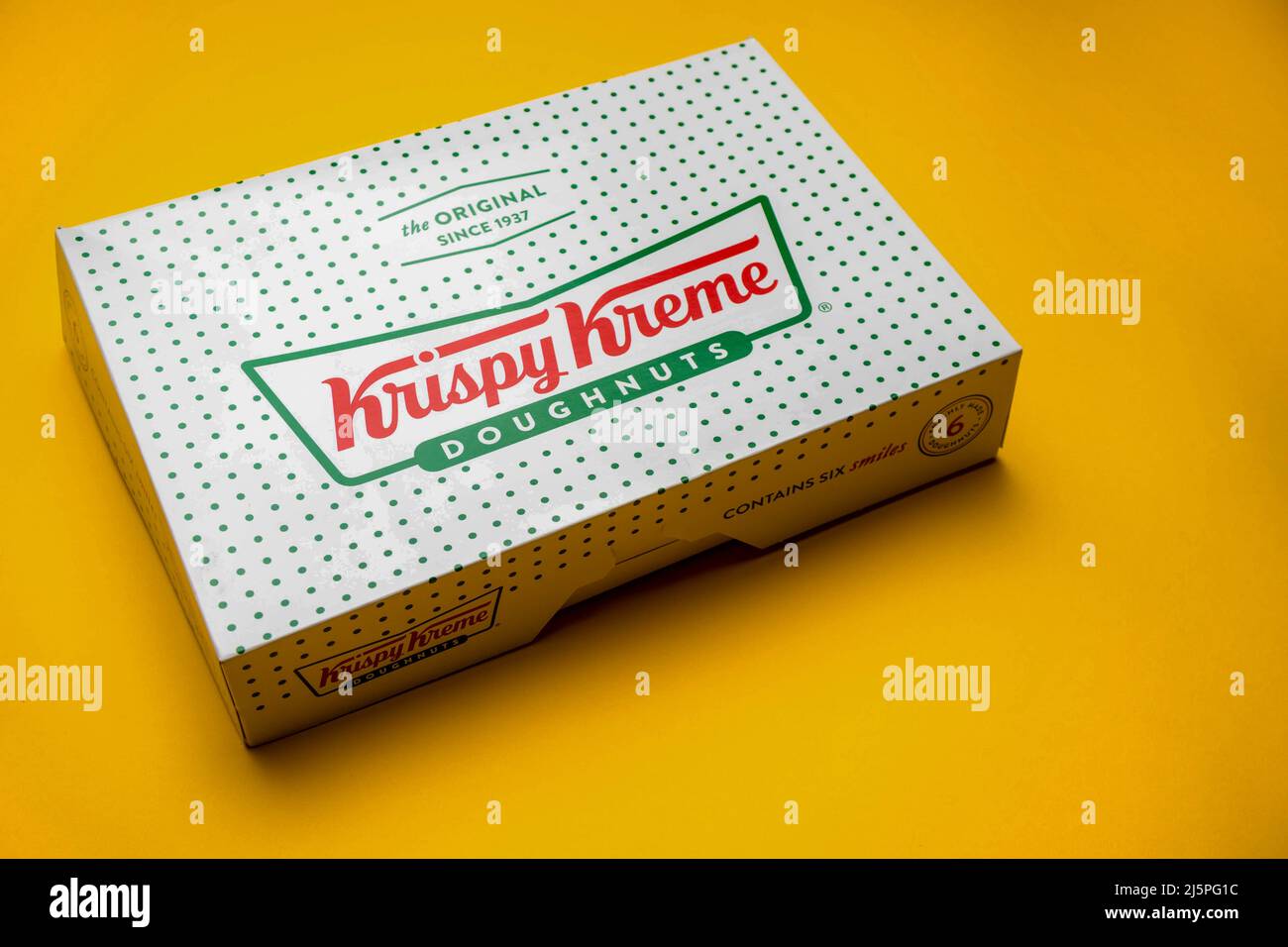 Londra, Regno Unito, 21st marzo 2022:- una scatola di Krispy Kreme Donuts su sfondo giallo Foto Stock