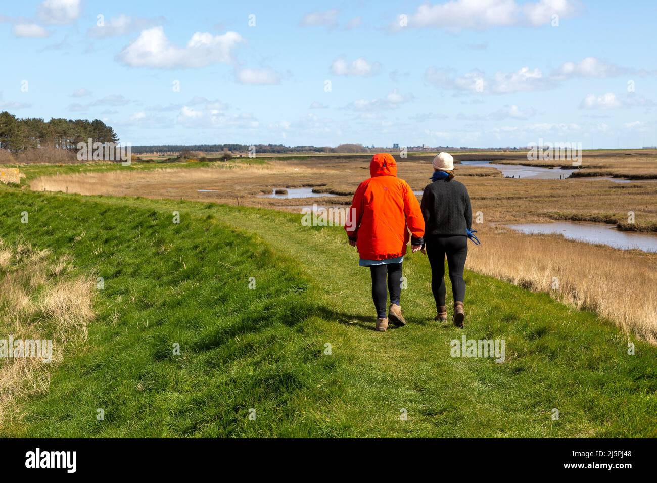 Due donne che camminano sul sentiero attraverso la palude di sale, il fiume ore, vicino Boyton, Suffolk, Inghilterra, REGNO UNITO Foto Stock