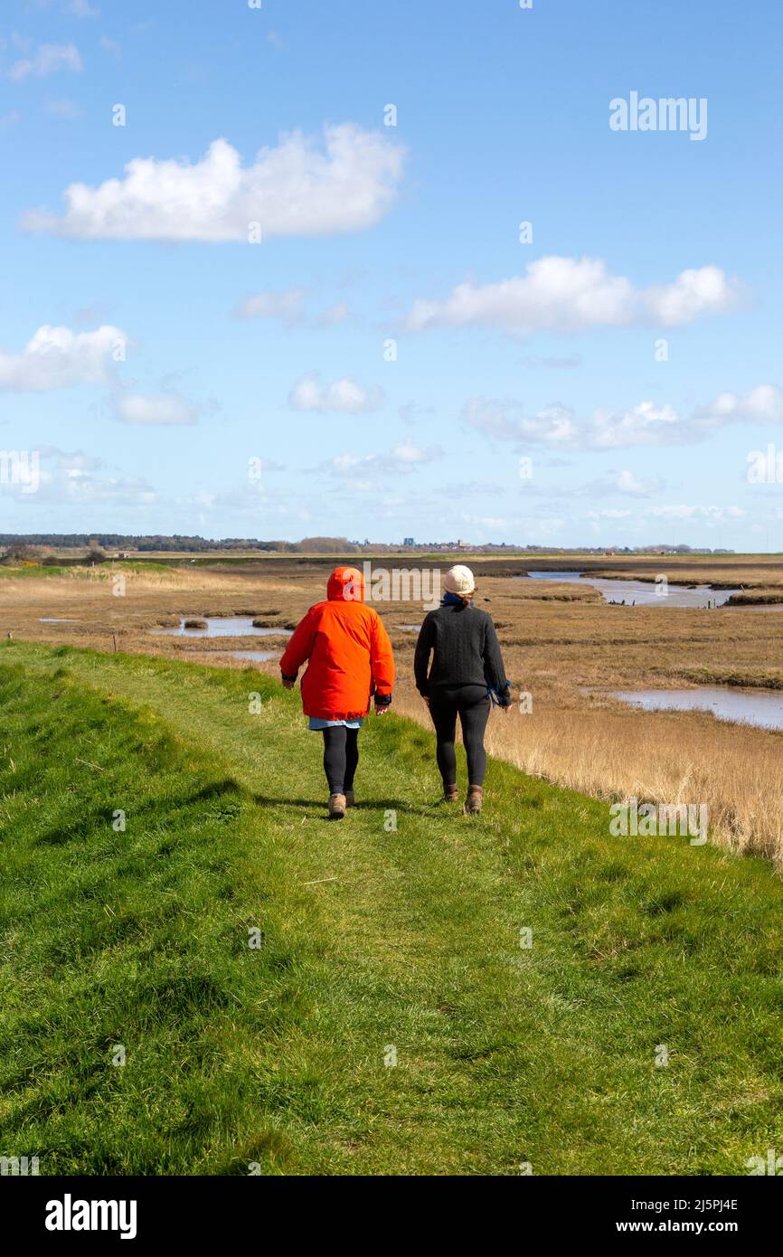 Due donne che camminano sul sentiero attraverso la palude di sale, il fiume ore, vicino Boyton, Suffolk, Inghilterra, REGNO UNITO Foto Stock